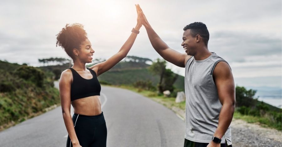 Ein Sportlerpaar gibt sich High Five nach dem Training.