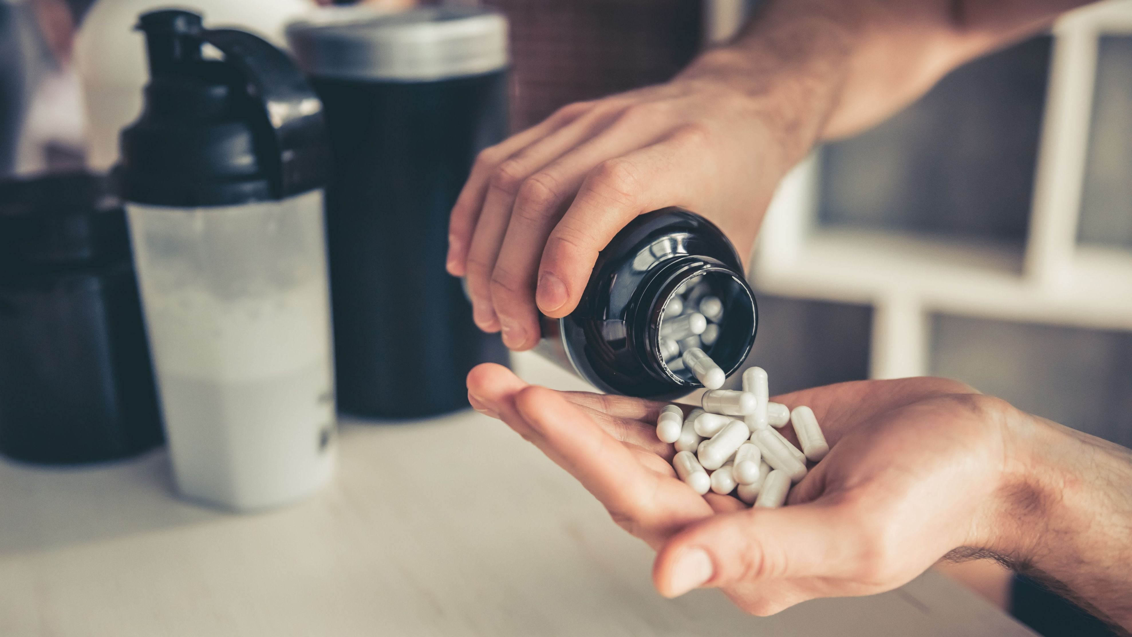 Sportler nimmt Kapseln als Symbol für Magnesium bei Muskelkater.