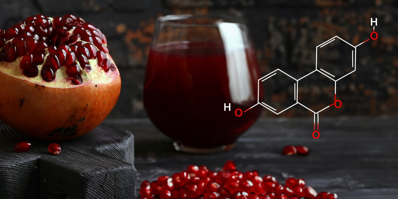 Ein aufgeschnittener Granatapfel mit roten Kernen liegt neben einem Glas mit Granatapfelsaft. Überlagert ist eine chemische Strukturformel von Urolithin-A.