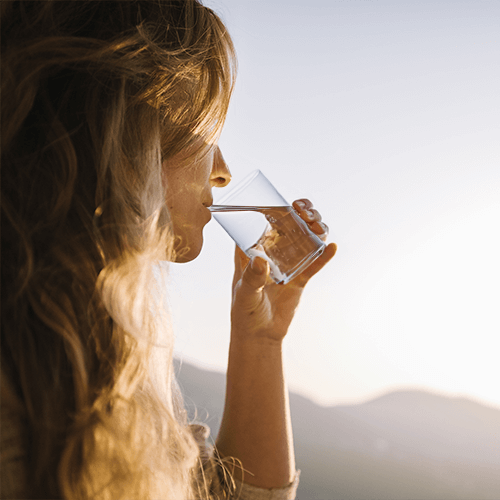 Frau trinkt ein Glas Wasser