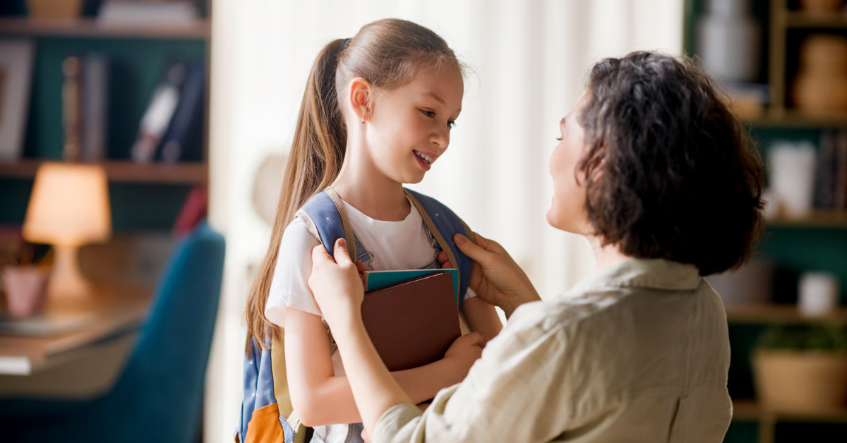 Mutter richtet ihrer Tochter den Schulranzen für den Schulanfang und den ersten Schultag.