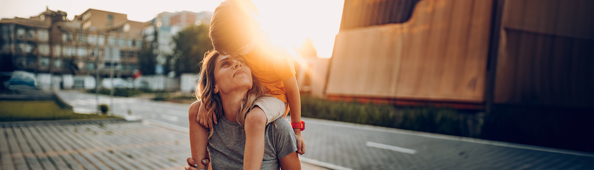 Eine Mutter trägt ihren Sohn auf die Schultern und befinden sich in der Stadt