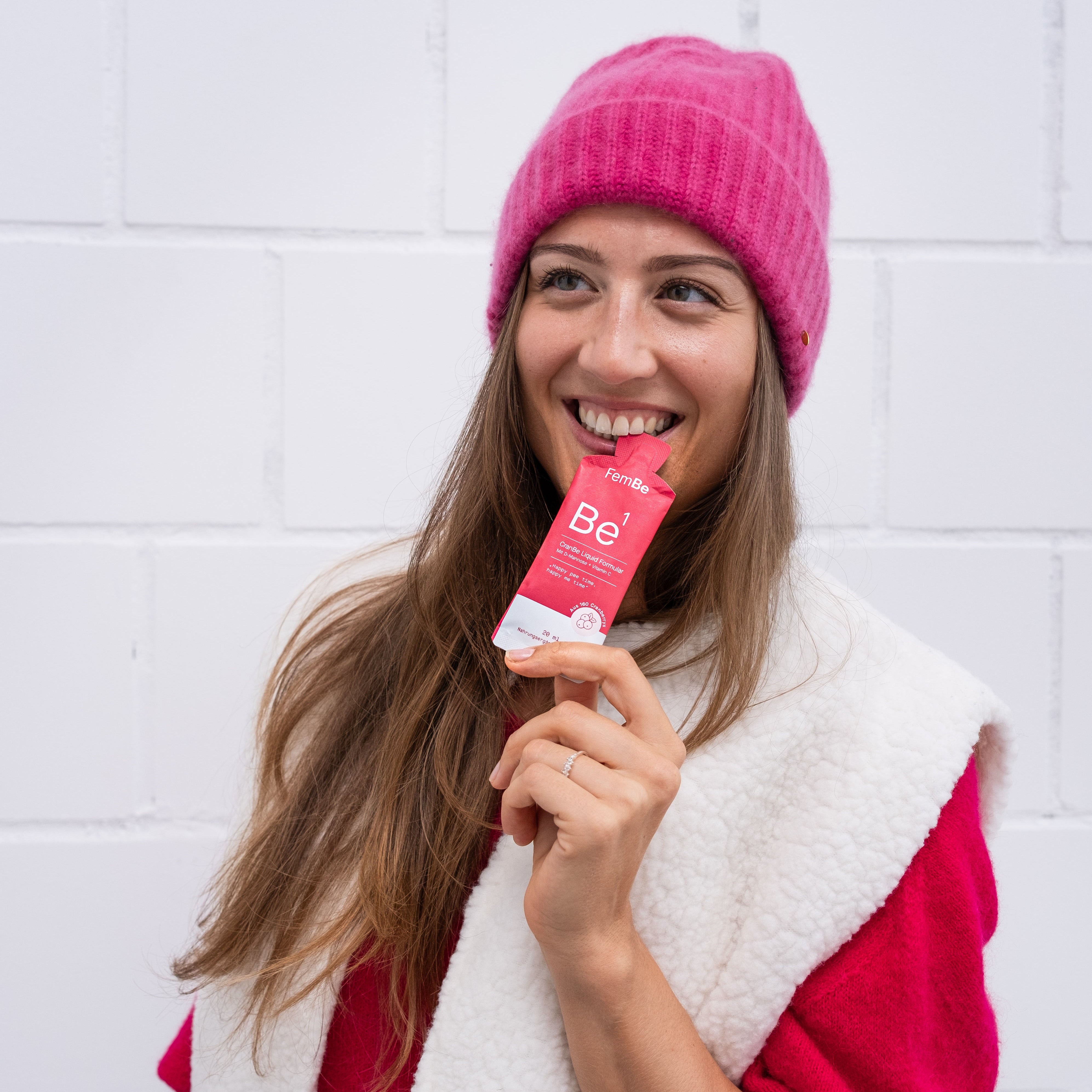 FemBe Cranberry Konzentrat für Frauen, Frau mit Sachet in Winterkleidung