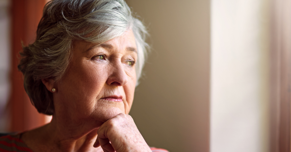 Nachdenkliche ältere Frau am Fenster