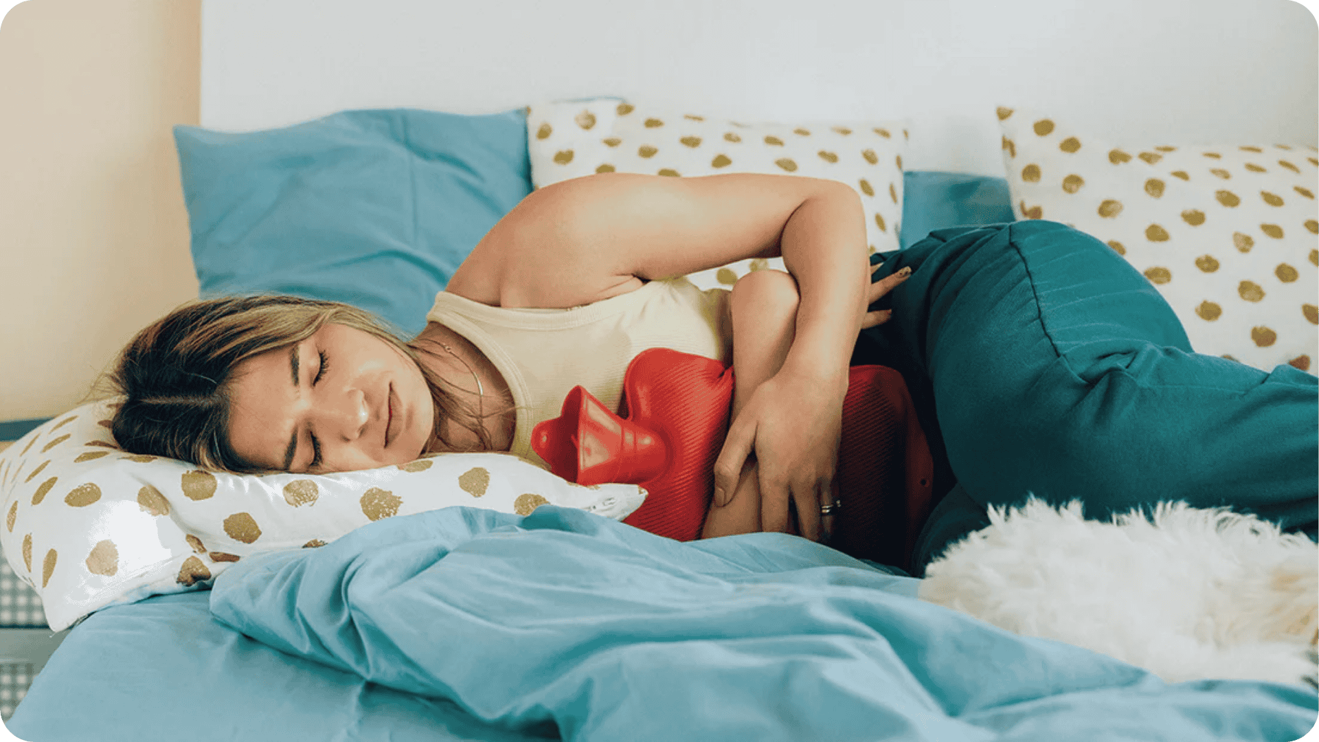 Frau mit Unterleibsschmerzen im Bett