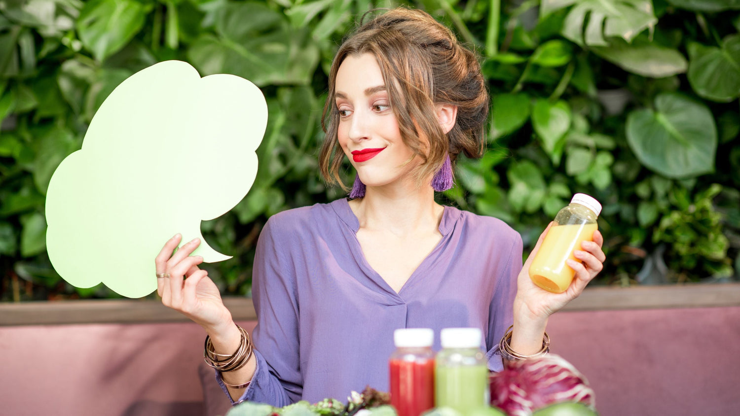 Frau hält eine Saftflasche in der Hand und blickt auf eine leere Gedankenblase – Symbol für verbreitete Mythen rund um Detox und Entgiftung des Körpers.