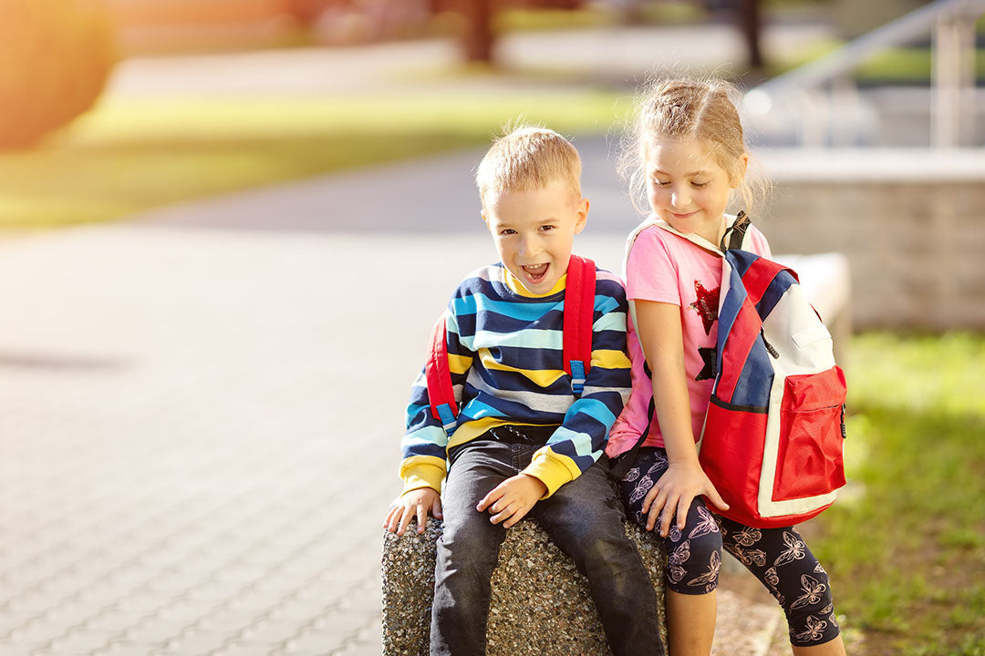 Zwei Kinder mit Schulranzen