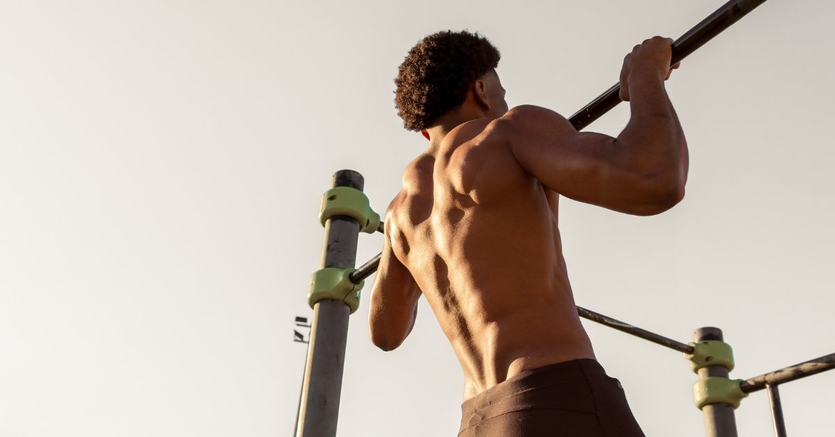 Sportler trainiert Klimmzüge als Beispiel für Krafttraining, bei dem die Kreatin Wirkung relevant sein kann.