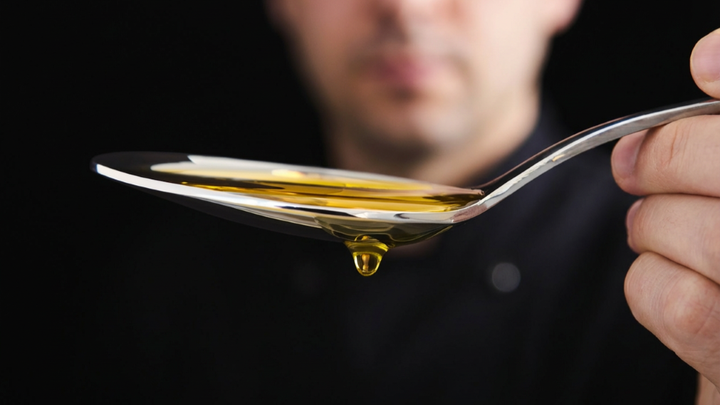 Nahaufnahme eines Löffels mit goldgelbem Leinöl – symbolische Darstellung von pflanzlichen Fettsäuren wie Alpha-Linolensäure (ALA).