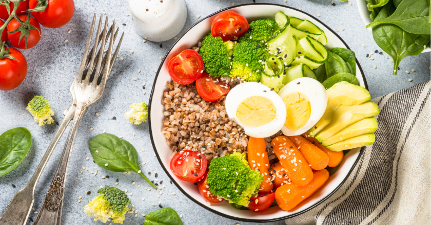 Bunte Bowl mit Brokkoli, Avocado, Eiern, Buchweizen, Karotten und frischem Gemüse als natürliche Mikronährstoffquellen.