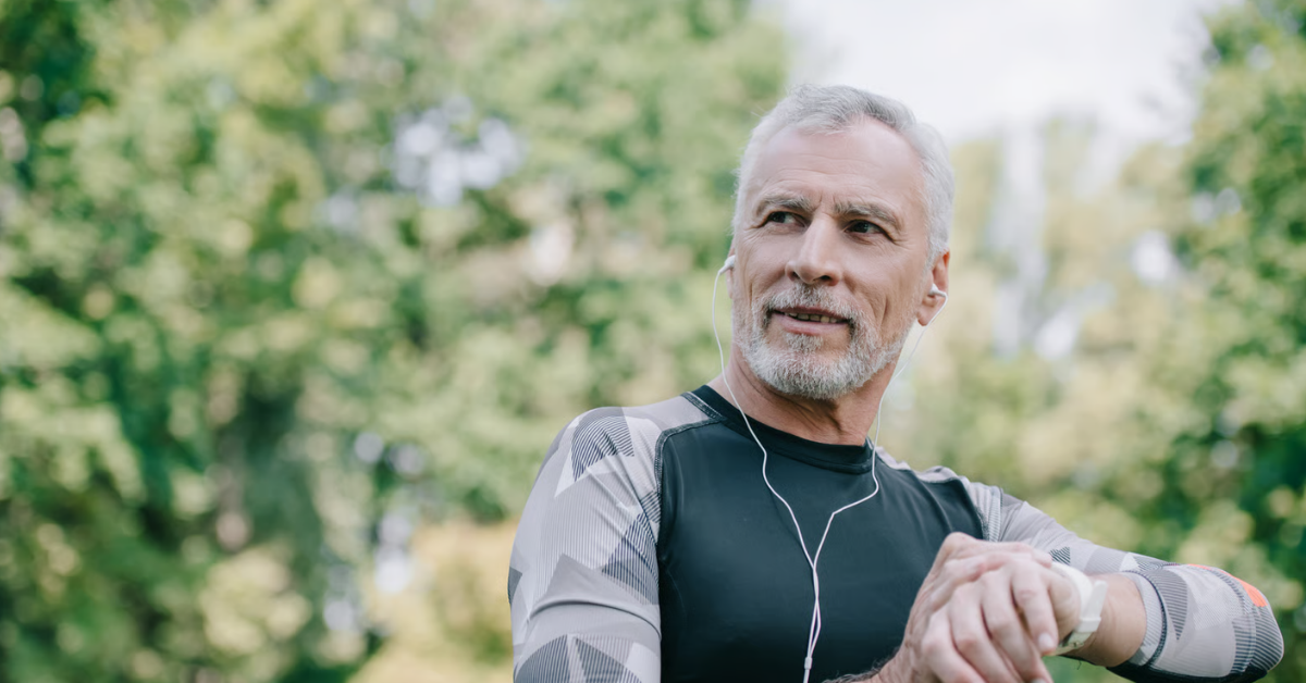 Älterer sportlicher Mann kontrolliert beim Training im Freien seine Armbanduhr – MSM Dosierung im Zusammenhang mit sportlicher Aktivität.