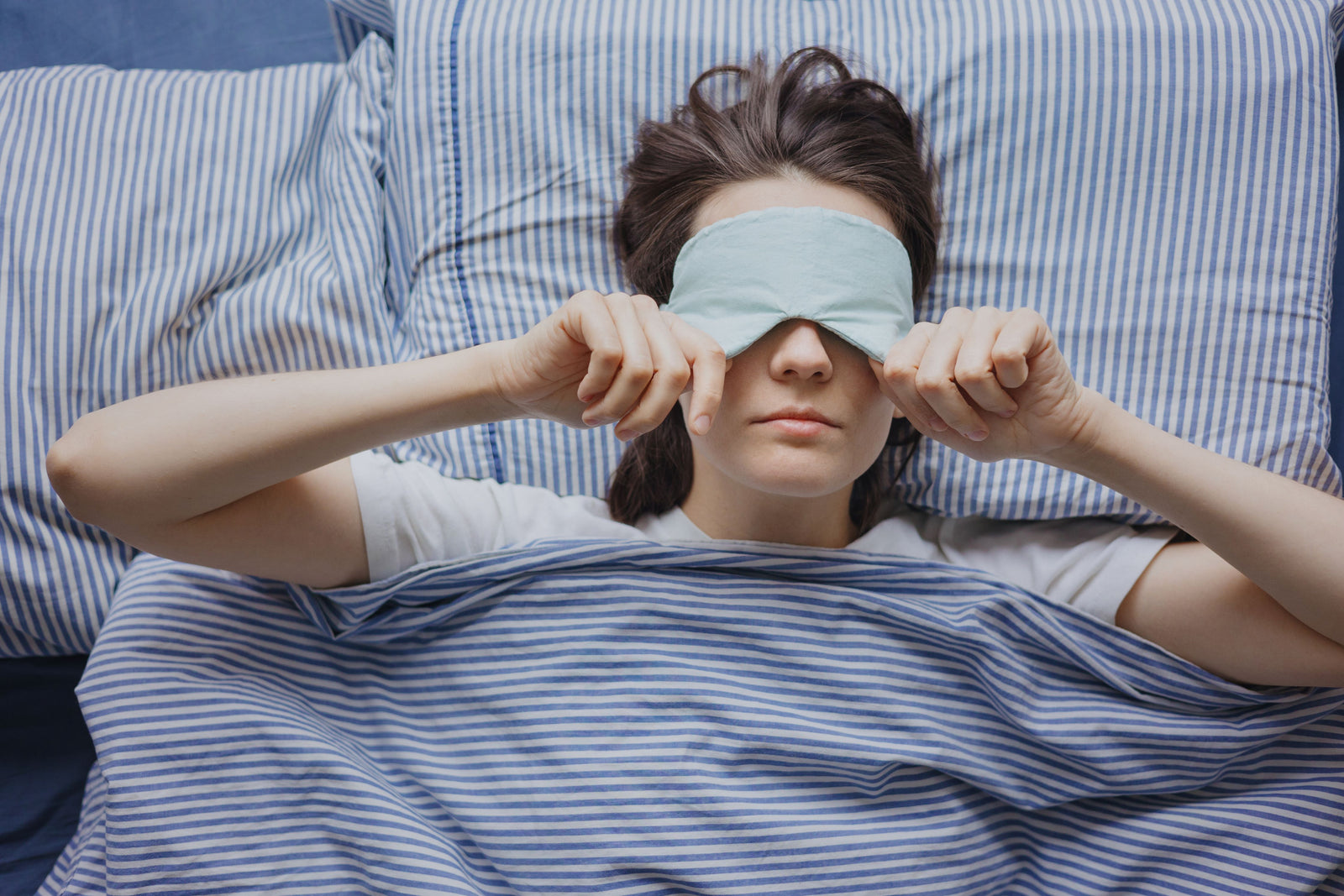 Frau mit Schlafmaske im Bett