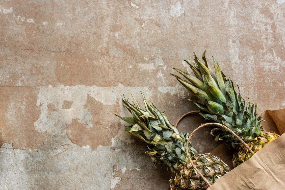 Ananas auf rot-beigem Stein-Hintergrund