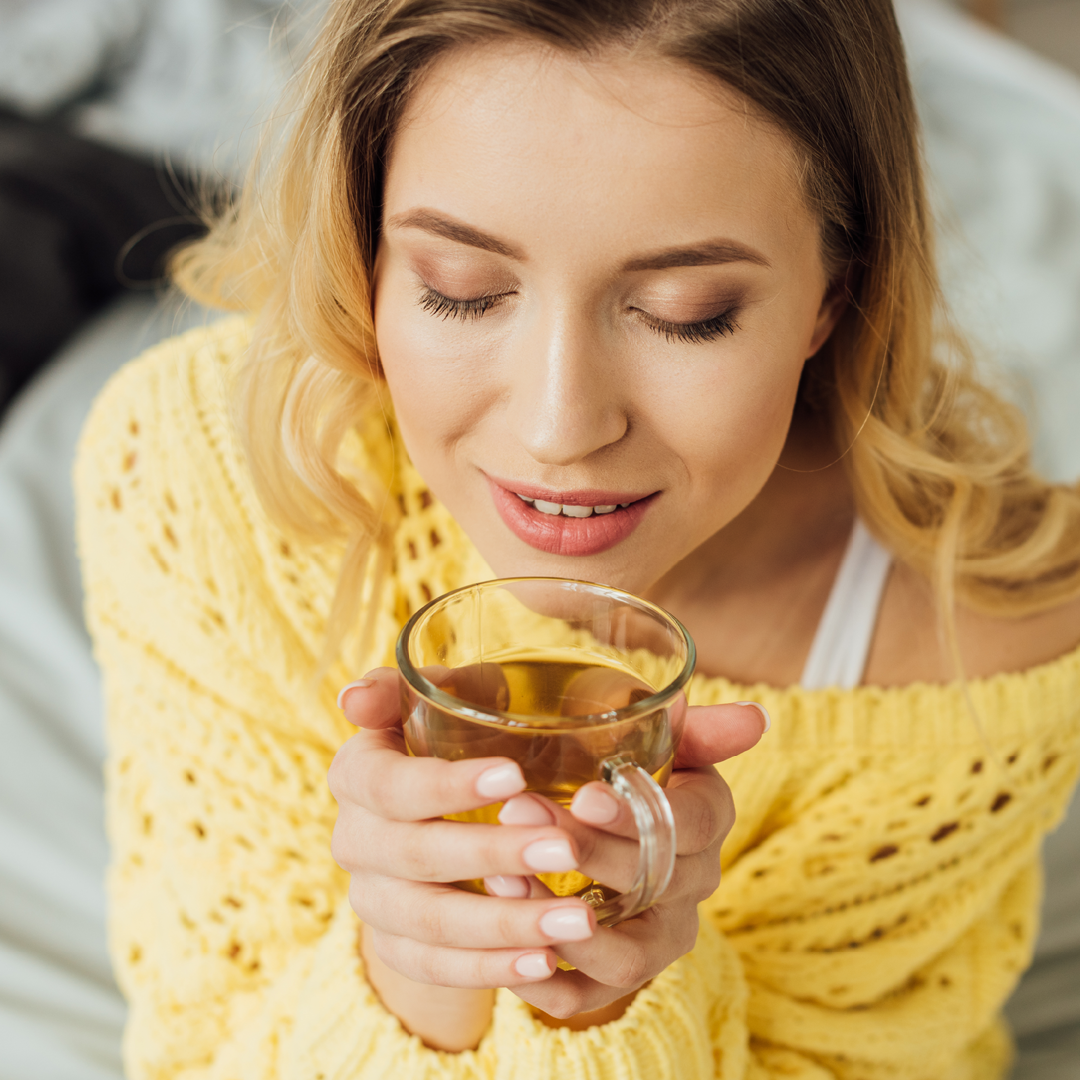 Eine Frau den grünen Hafertee am trinken