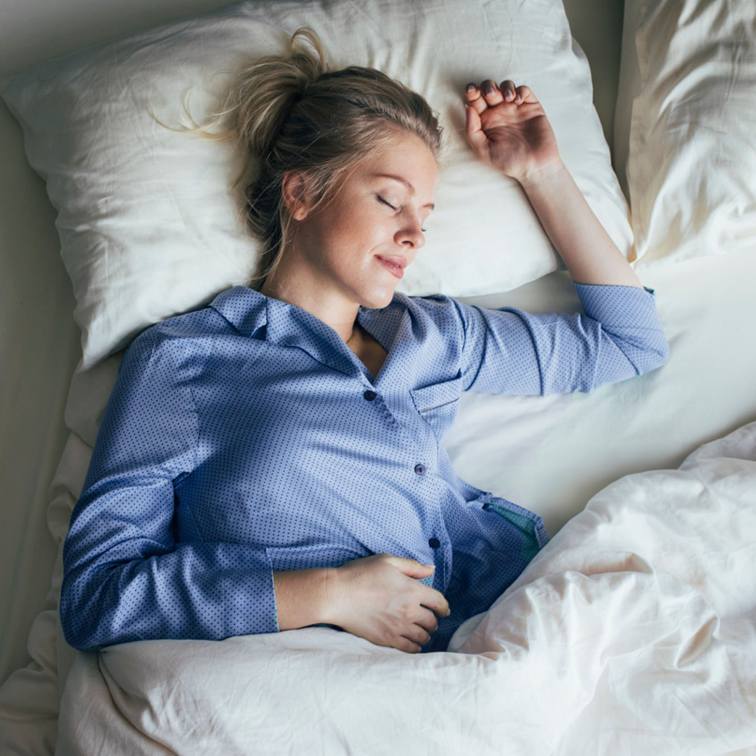 Frau mit blauem Pyjama im Bett