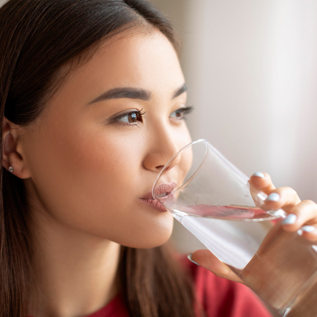 Eine Frau trinkt ein Glas Wasser