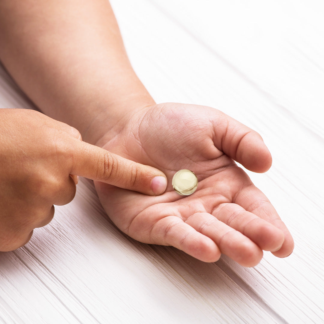 Mini Pearlz White Omega Algenöl in der Hand eines Kindes